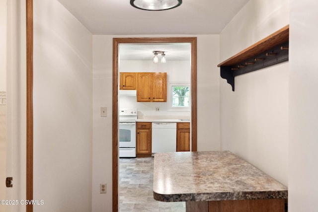 110 W 8th St, Watsontown, PA 17777 - kitchen featuring white appliances, brown cabinetry, and under cabinet range hood