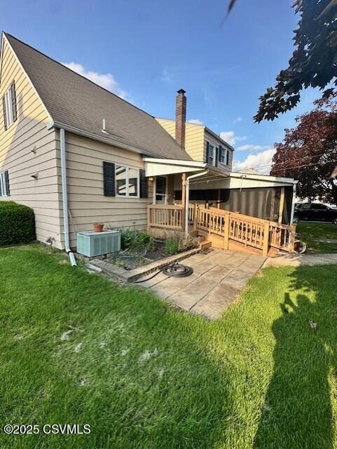 1030 Orange St, Berwick, PA 18603 - back of house featuring a patio area, a lawn, and a chimney