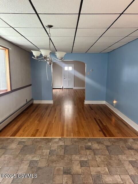 1030 Orange St, Berwick, PA 18603 - empty room with a drop ceiling, a baseboard heating unit, arched walkways, and a chandelier