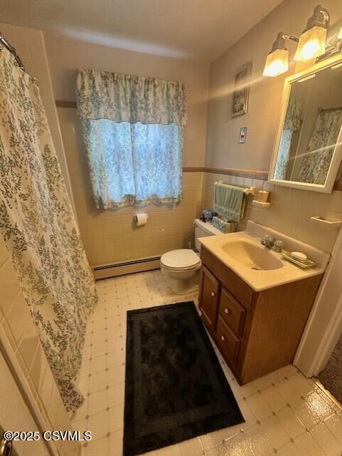 1030 Orange St, Berwick, PA 18603 - full bathroom featuring a baseboard radiator, vanity, tile walls, a wainscoted wall, and a shower with curtain