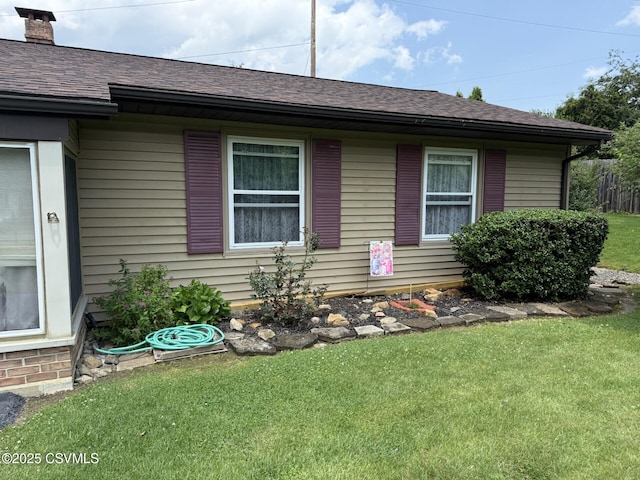 128 Woodside Rd, Sunbury, PA 17801 - view of property exterior featuring a yard, a shingled roof, and a chimney