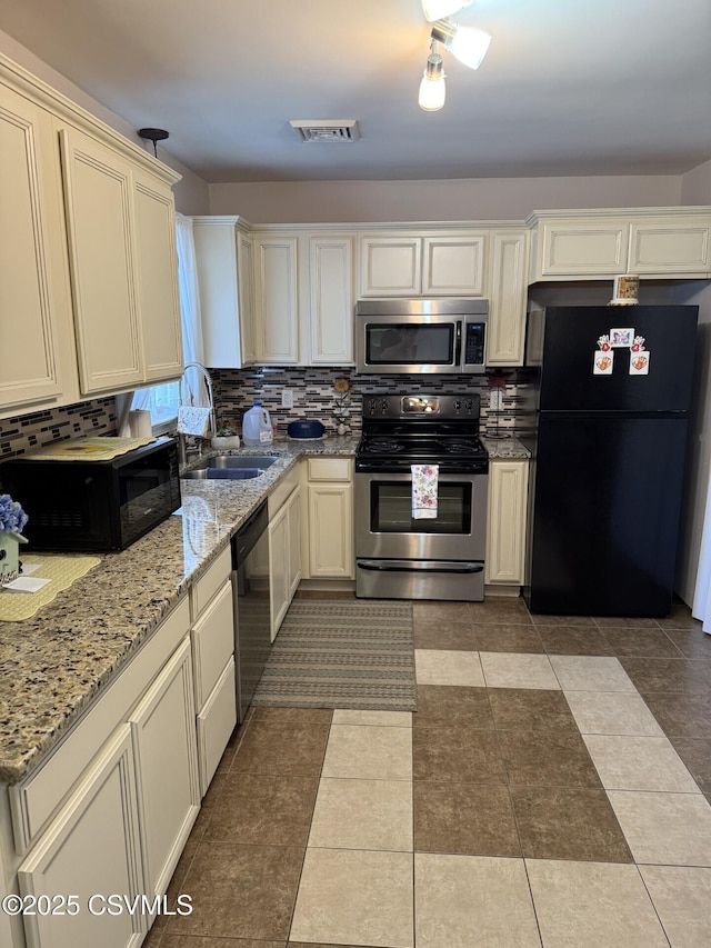 128 Woodside Rd, Sunbury, PA 17801 - kitchen with black appliances, backsplash, and light stone counters