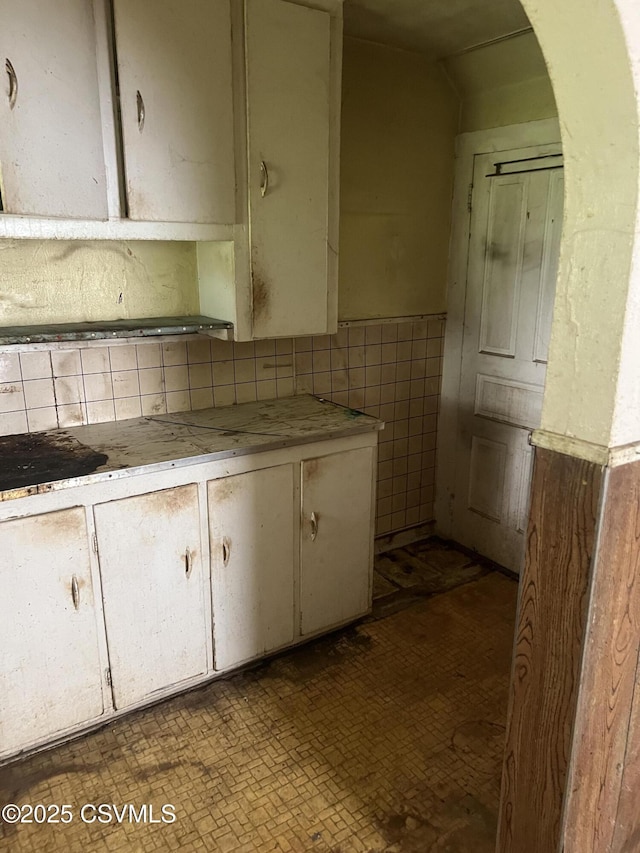 612-614 1st St, Nescopeck, PA 18635 - kitchen featuring light countertops, arched walkways, tile walls, and tasteful backsplash