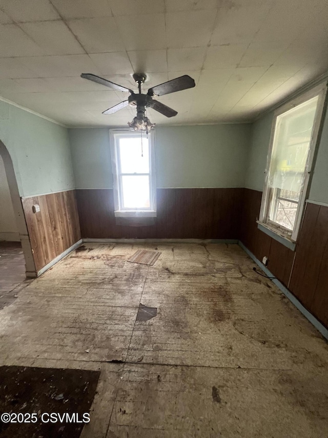 612-614 1st St, Nescopeck, PA 18635 - empty room featuring wainscoting, wood walls, a ceiling fan, ornamental molding, and arched walkways