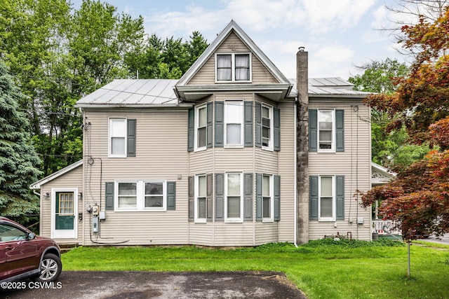 109 W Ninth St, Watsontown, PA 17777 - view of front facade with a chimney, a front lawn, and a metal roof