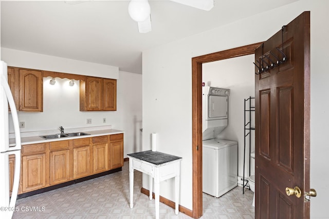 109 W Ninth St, Watsontown, PA 17777 - kitchen featuring stacked washer / drying machine, light flooring, freestanding refrigerator, light countertops, and brown cabinets