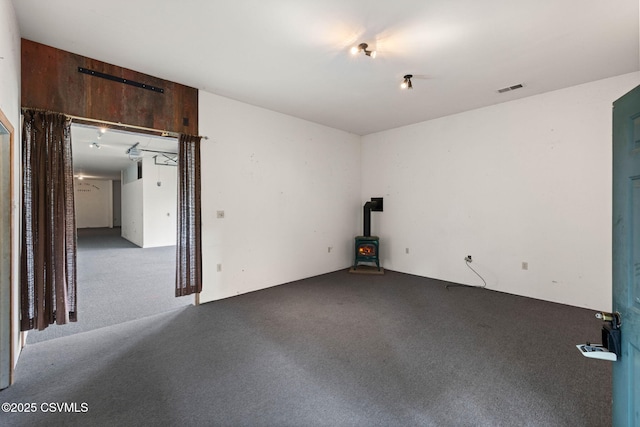 109 W Ninth St, Watsontown, PA 17777 - empty room with carpet flooring and a wood stove