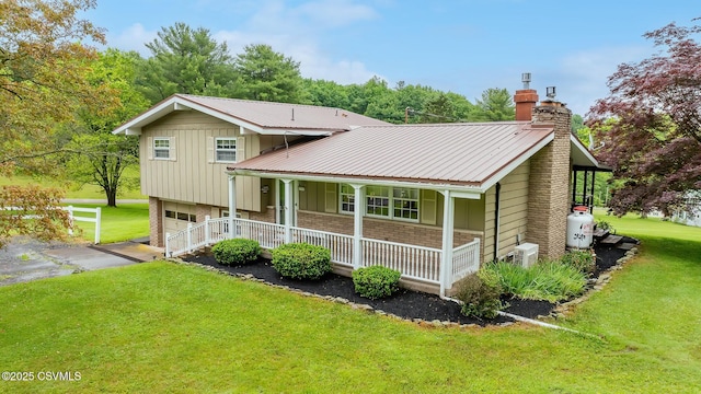 157 Distillery Hill Rd, Benton, PA 17814 - split level home with covered porch, a chimney, asphalt driveway, brick siding, and a front yard