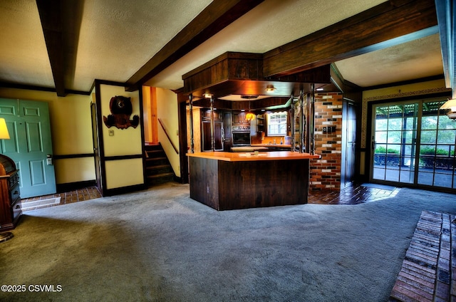 157 Distillery Hill Rd, Benton, PA 17814 - kitchen with beam ceiling, dark colored carpet, butcher block countertops, a textured ceiling, and a center island