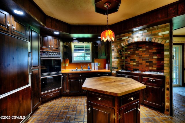 157 Distillery Hill Rd, Benton, PA 17814 - kitchen featuring butcher block counters, brick flooring, hanging light fixtures, and paneled refrigerator