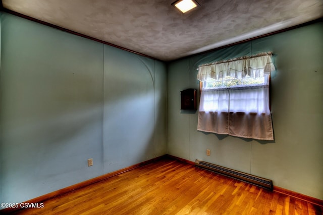 157 Distillery Hill Rd, Benton, PA 17814 - empty room with baseboard heating, wood finished floors, and a textured ceiling