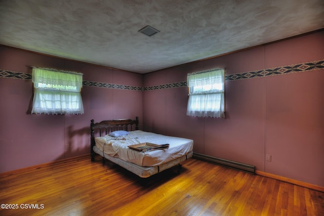 157 Distillery Hill Rd, Benton, PA 17814 - bedroom featuring a baseboard heating unit, wood finished floors, and a textured ceiling