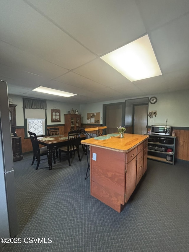 1211 W Mulberry St, Coal Township, PA 17866 - kitchen with stainless steel microwave, dark carpet, wainscoting, wood counters, and a kitchen island