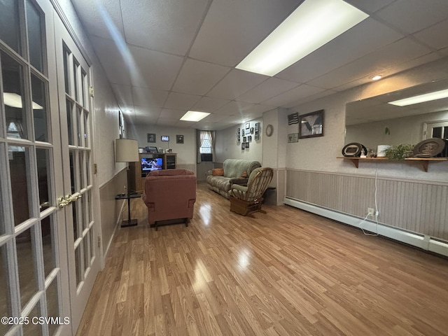 1211 W Mulberry St, Coal Township, PA 17866 - living area with wood finished floors, a baseboard heating unit, a drop ceiling, and a wainscoted wall