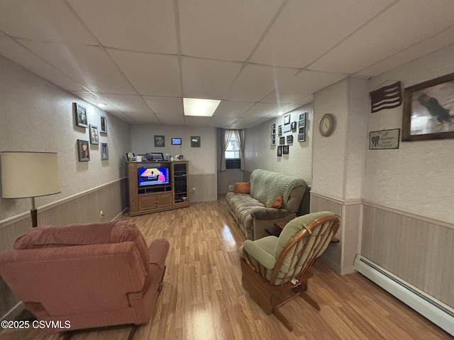 1211 W Mulberry St, Coal Township, PA 17866 - living area featuring a baseboard radiator, wood finished floors, wainscoting, a drop ceiling, and wooden walls