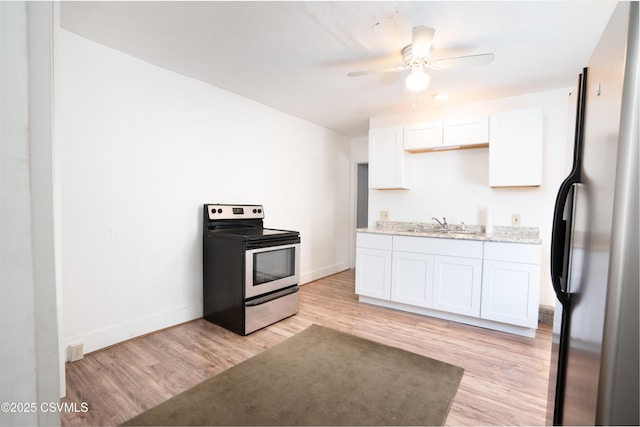 126-128 Murray Ave, Bloomsburg, PA 17815 - kitchen with stainless steel electric stove, freestanding refrigerator, light wood-style flooring, white cabinets, and light stone counters