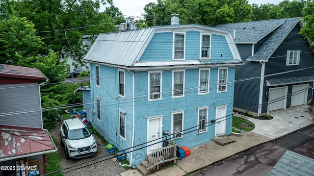126-128 Murray Ave, Bloomsburg, PA 17815 - view of front of home with an attached garage, stucco siding, driveway, cooling unit, and a metal roof