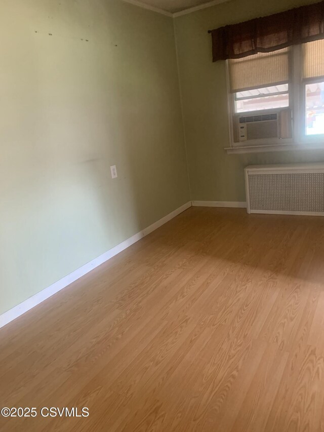 1542 1st Ave, Berwick, PA 18603 - unfurnished room with radiator, cooling unit, wood finished floors, and ornamental molding