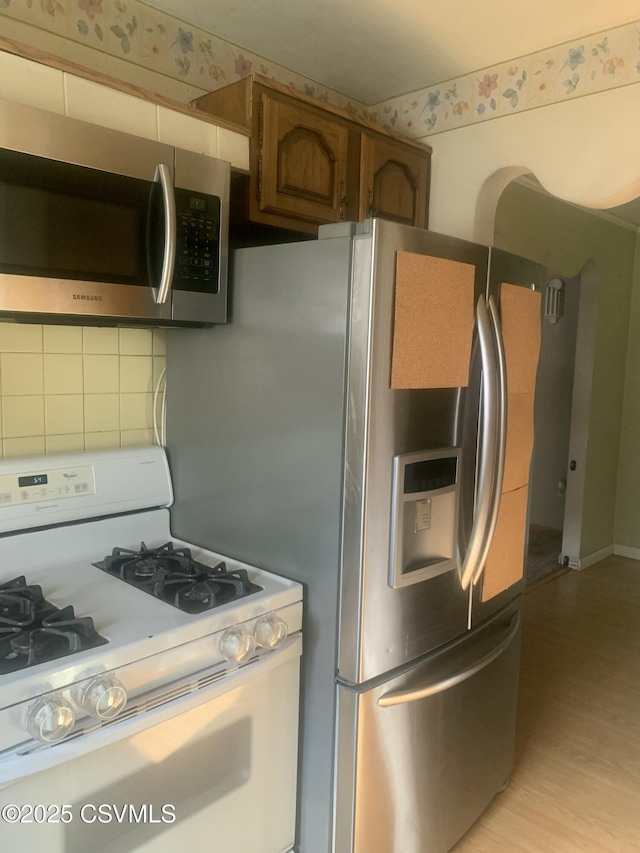 1542 1st Ave, Berwick, PA 18603 - kitchen with appliances with stainless steel finishes, decorative backsplash, light wood-type flooring, and brown cabinetry