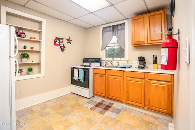 846-848 Orange St, Berwick, PA 18603 - kitchen with white appliances, light countertops, a paneled ceiling, brown cabinets, and light stone finish floors