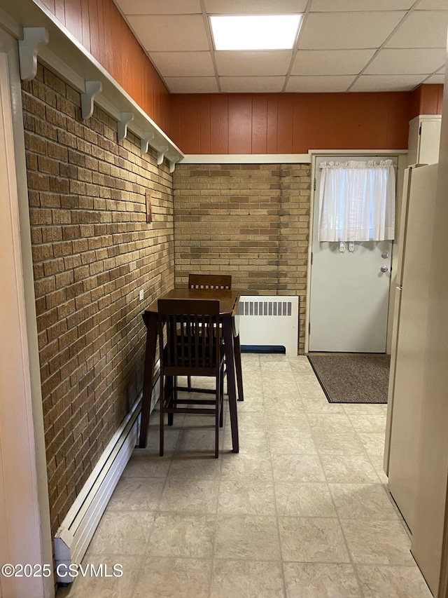 846-848 Orange St, Berwick, PA 18603 - dining room with radiator heating unit, brick wall, a baseboard radiator, and a drop ceiling