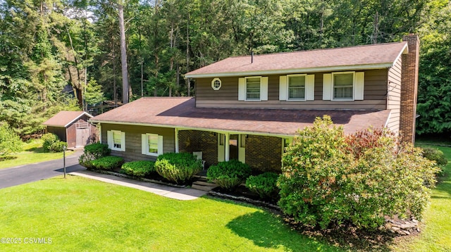 39 Mckendree Rd, Shickshinny, PA 18655 - view of front of home with a chimney, a front lawn, a storage unit, brick siding, and a shingled roof
