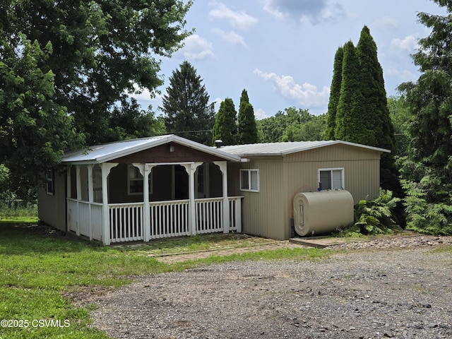 1824 Smalsh Barrick Rd, Middleburg, PA 17842 - view of front of property featuring heating fuel, a porch, dirt driveway, and a metal roof