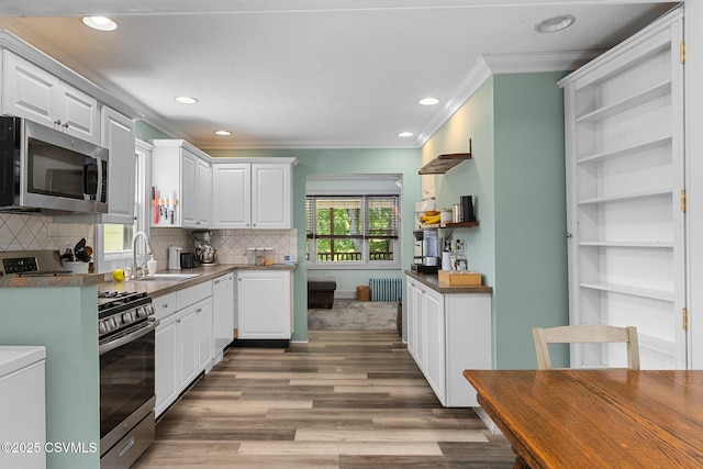 378 Drinker St, Bloomsburg, PA 17815 - kitchen featuring appliances with stainless steel finishes, ornamental molding, wood finished floors, white cabinetry, and radiator heating unit