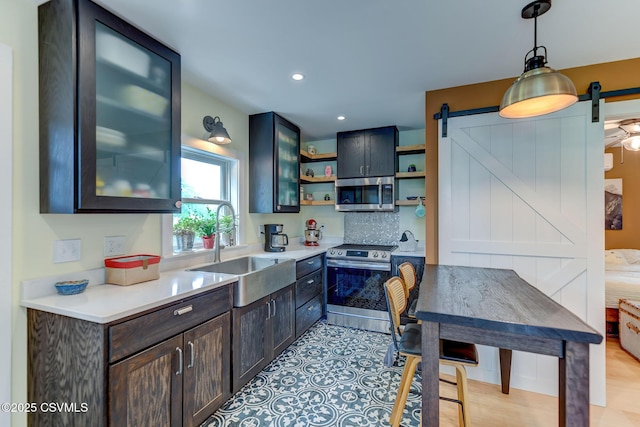 909 Fair St, Nescopeck, PA 18635 - kitchen with stainless steel appliances, open shelves, a barn door, decorative light fixtures, and light countertops