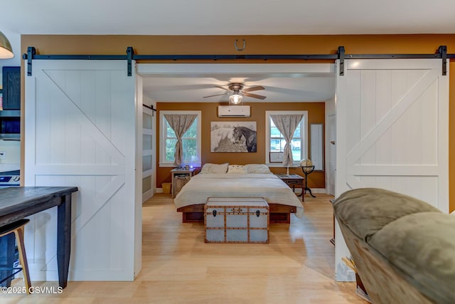 909 Fair St, Nescopeck, PA 18635 - bedroom featuring a barn door, a wall mounted AC, and light wood-style flooring