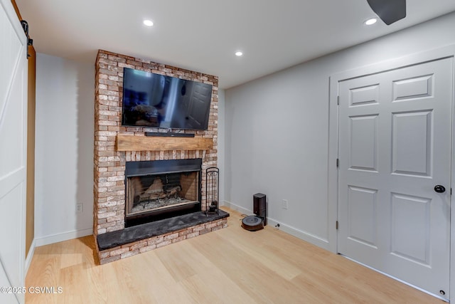 909 Fair St, Nescopeck, PA 18635 - unfurnished living room with wood finished floors, a fireplace, recessed lighting, and a barn door