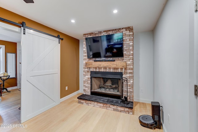 909 Fair St, Nescopeck, PA 18635 - living area featuring wood finished floors, a barn door, recessed lighting, and a brick fireplace