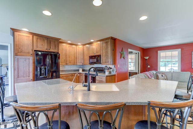 909 Fair St, Nescopeck, PA 18635 - kitchen featuring black appliances, recessed lighting, a kitchen bar, backsplash, and a large island with sink