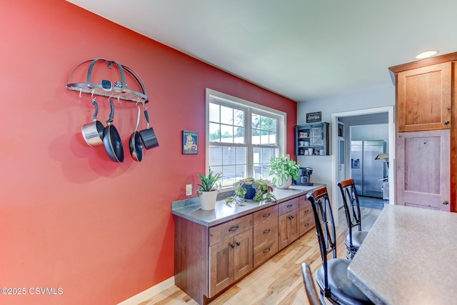 909 Fair St, Nescopeck, PA 18635 - kitchen with light wood-style floors, brown cabinetry, and stainless steel fridge