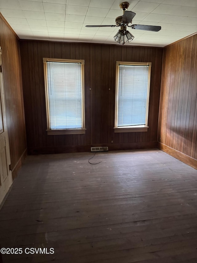 615 Broad St, Berwick, PA 18603 - empty room with hardwood / wood-style floors, a ceiling fan, and wooden walls