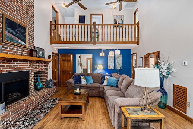 68 March Cir, Winfield, PA 17889 - living area featuring a ceiling fan, a high ceiling, hardwood / wood-style floors, and a fireplace