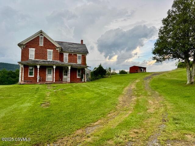 352 Turkey Hill Rd, Elysburg, PA 17824 - rear view of property with a yard, a porch, a chimney, and brick siding