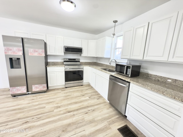 1613 2nd Ave, Berwick, PA 18603 - kitchen with appliances with stainless steel finishes, white cabinetry, light stone countertops, and pendant lighting