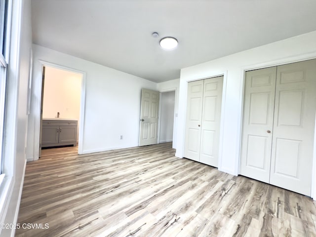 1613 2nd Ave, Berwick, PA 18603 - unfurnished bedroom with multiple closets, wood finished floors, and ensuite bathroom
