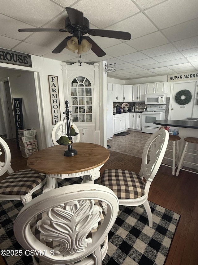 223 N Vine St, Shamokin, PA 17872 - dining area featuring dark wood-style flooring, ceiling fan, and a paneled ceiling
