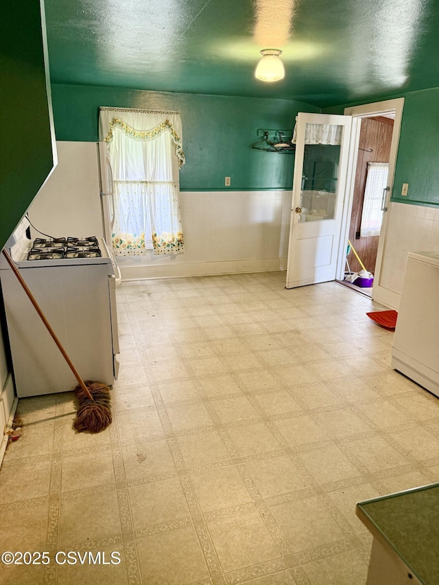 1507 Fairview Ave, Berwick, PA 18603 - kitchen with white gas range, wainscoting, plenty of natural light, tile patterned floors, and a textured ceiling