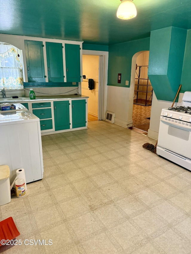 1507 Fairview Ave, Berwick, PA 18603 - kitchen featuring green cabinets, arched walkways, white range with gas cooktop, and light flooring