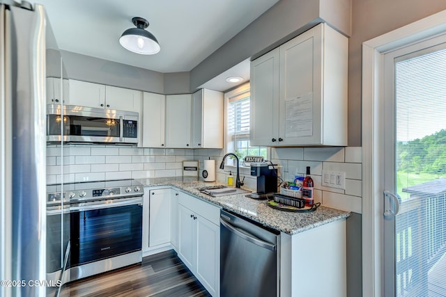 5 Williamsburg Blvd, Bloomsburg, PA 17815 - kitchen with stainless steel appliances, white cabinets, tasteful backsplash, light stone counters, and dark wood-style floors