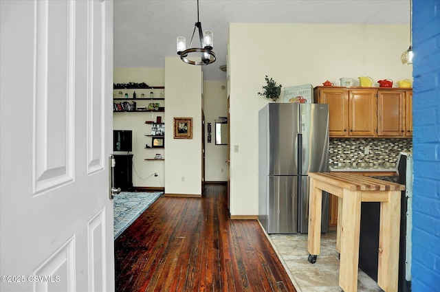 12 State School Rd, Selinsgrove, PA 17870 - kitchen with freestanding refrigerator, wood-type flooring, brown cabinetry, tasteful backsplash, and hanging light fixtures