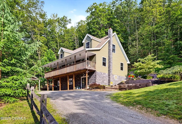 178 Schooners Run, Shickshinny, PA 18655 - view of front of house featuring gravel driveway, a wooden deck, stone siding, a chimney, and a front yard