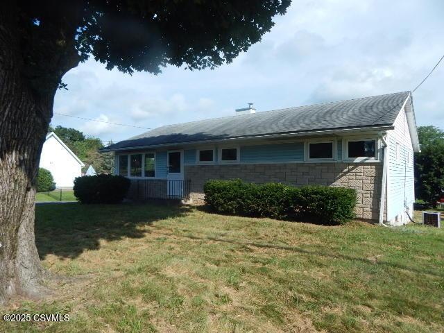 404 W Center St, Elysburg, PA 17824 - view of front of home featuring a front yard, stone siding, and roof with shingles