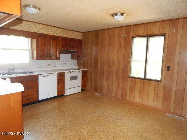 404 W Center St, Elysburg, PA 17824 - kitchen featuring white appliances, wood walls, extractor fan, brown cabinetry, and light countertops