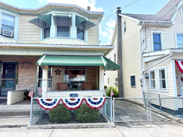 230 S 6th St, Shamokin, PA 17872 - view of front of home featuring a gate, brick siding, and covered porch