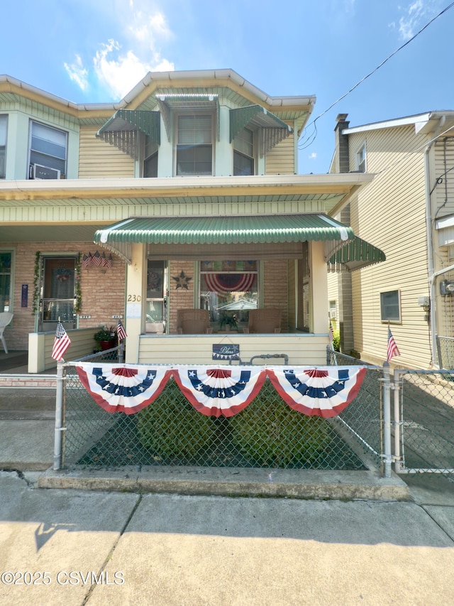 230 S 6th St, Shamokin, PA 17872 - view of front of property with a porch, brick siding, a fenced front yard, and a gate