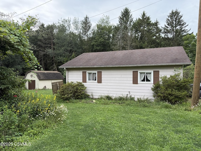 25 Wolfe Rd, Nescopeck, PA 18635 - view of side of property with a storage shed, a lawn, and a shingled roof